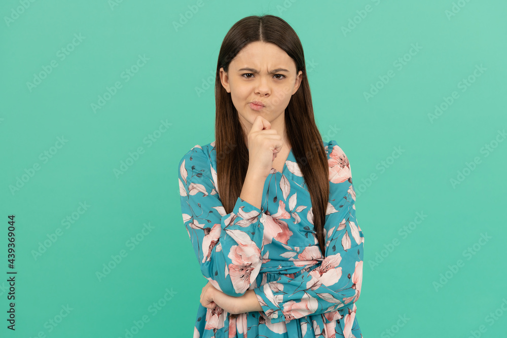 Fototapeta premium Serious school-aged girl child keep thinking blue background, think