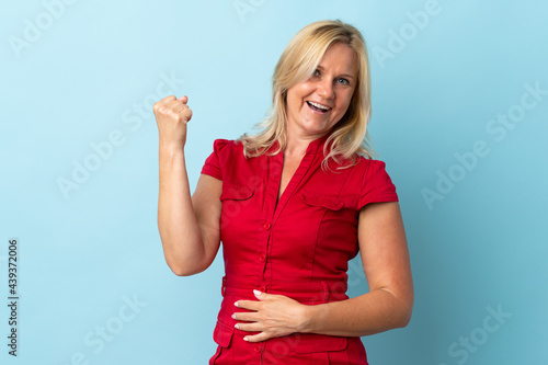 Wallpaper Mural Middle age woman isolated on blue background celebrating a victory Torontodigital.ca