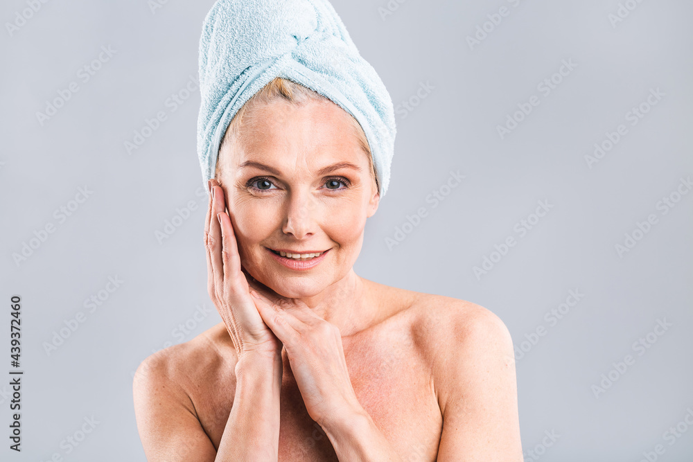 Portrait of smiling senior woman feeling soft skin with hand after spa bath. Mature woman draped in towel looking at camera. Lady in bathrobe after shower isolated over white background. Portrait of smiling senior woman feeling soft skin with hand after spa bath. Mature woman draped in towel looking at camera. Lady in bathrobe after shower isolated over white background.