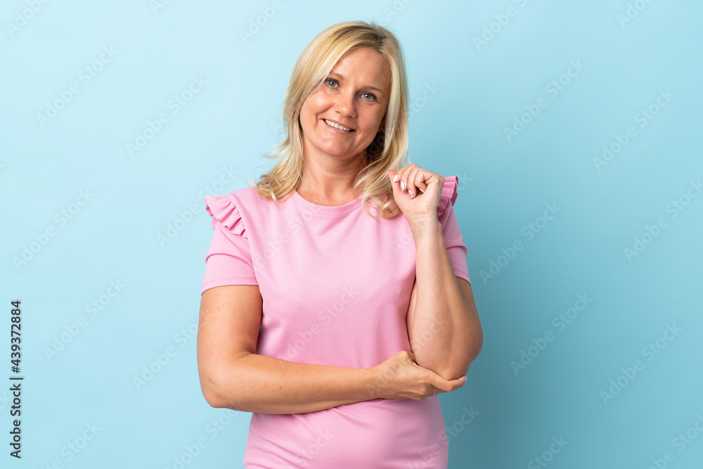 Obraz premium Middle age woman isolated on blue background laughing