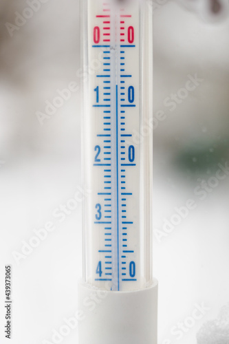 Detail of an outdoor mercury thermometer with a freezing value.