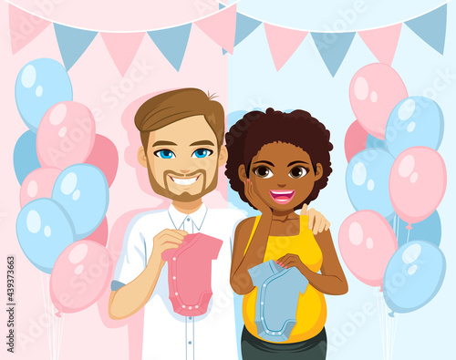 Young interracial couple together on gender reveal party holding blue and pink romper