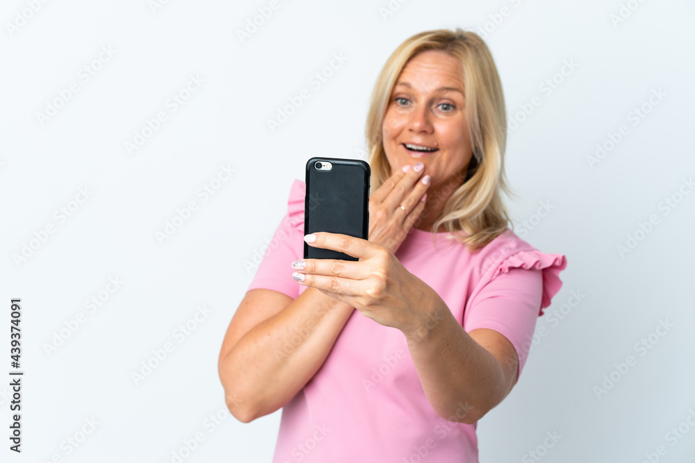 Middle age using mobile phone isolated on white background with surprise and shocked facial expression Middle age using mobile phone isolated on white background with surprise and shocked facial expression
