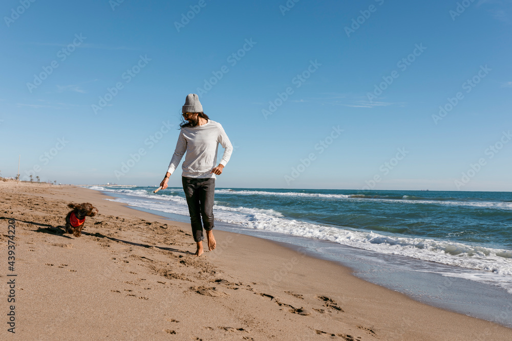 men and dog playing and having fun art the beach