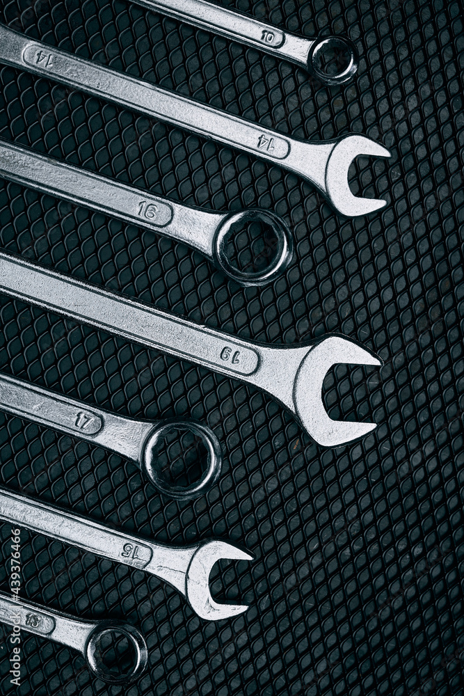 Fototapeta premium Set of chrome wrenches on steel surface. Mechanic tools for maintenance. Hardware tools to fix