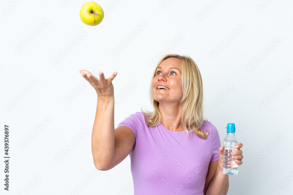 Middle age woman isolated on white background with an apple and with a bottle of water Middle age woman isolated on white background with an apple and with a bottle of water