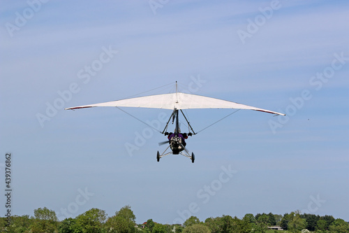 	
Ultralight airplane flying in a blue sky
