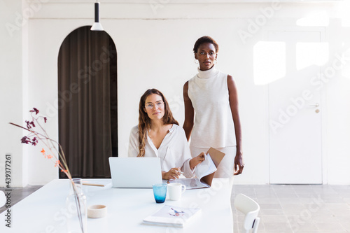 Contemporary multiethnic businesswomen in minimal office interior photo