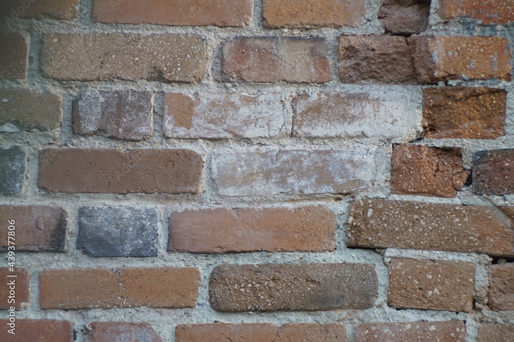 Photo of the texture. A section of 19th-century brickwork. The surface is severely damaged by time and repair attempts. Colors: red, white, brown. Photo of the texture. A section of 19th-century brickwork. The surface is severely damaged by time and repair attempts. Colors: red, white, brown.