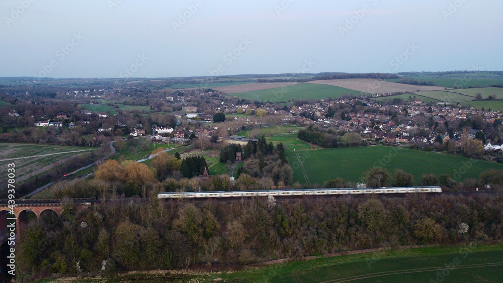 Train intersecting English countryside.