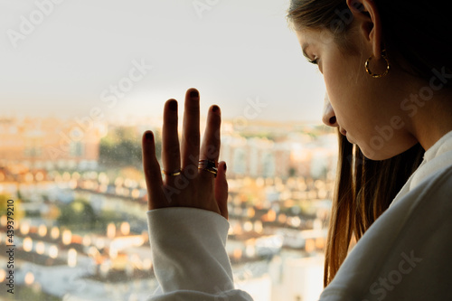 Portrait of teenager girl looking trough window 