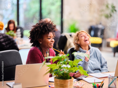 Businesswomen laughing at joke in office photo