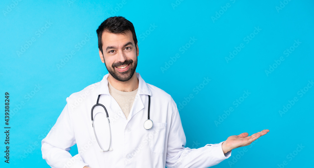 Young caucasian man over isolated background wearing a doctor gown and presenting something Young caucasian man over isolated background wearing a doctor gown and presenting something