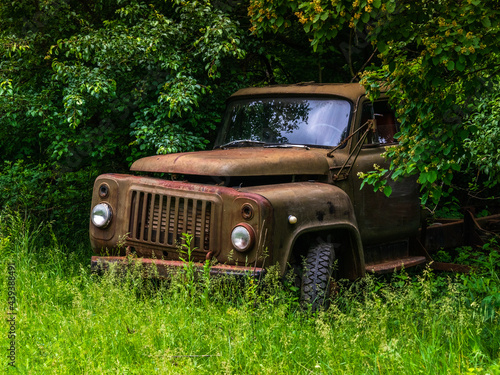 old lorry abandoned to rust in the forest on a summer day