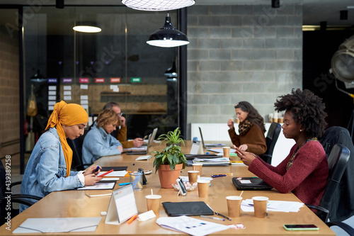 Multi-ethnic professionals working in office boardroom