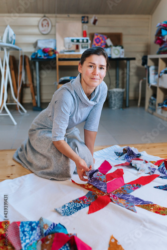 A woman is sewing patchwork in a home workshop. photo