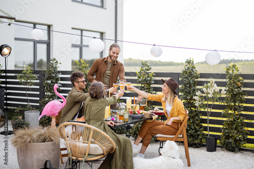 Canvas Print A group of young friends have delicious dinner, toasting and having great summer