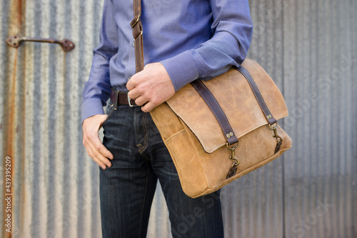 Man poses with leather messenger bag photo