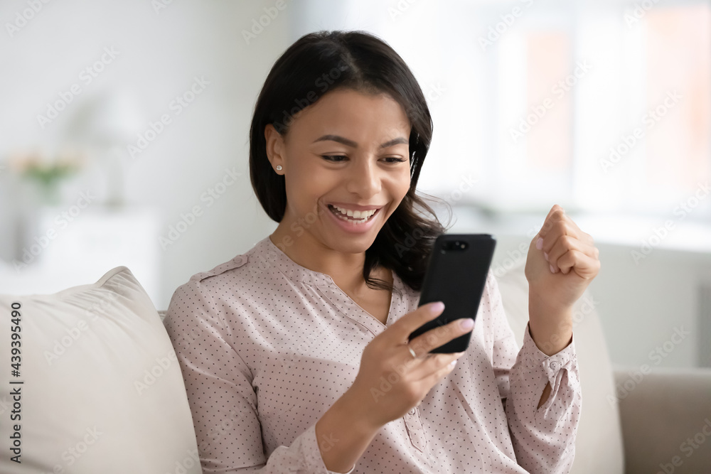 Happy African American woman with smartphone excited with good news, getting and reading message or using mobile phone for video call, looking at screen or webcam, speaking, smiling and laughing Happy African American woman with smartphone excited with good news, getting and reading message or using mobile phone for video call, looking at screen or webcam, speaking, smiling and laughing