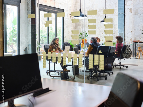 Coworkers behind glass wall with Kanban board photo