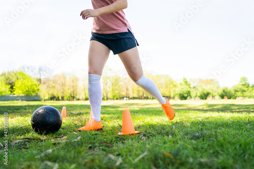 Young female soccer player practicing on field.