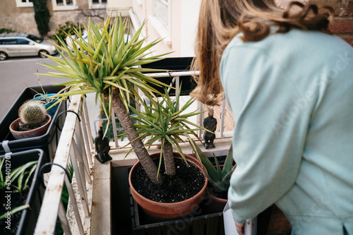 Woman watering plants in balcony photo