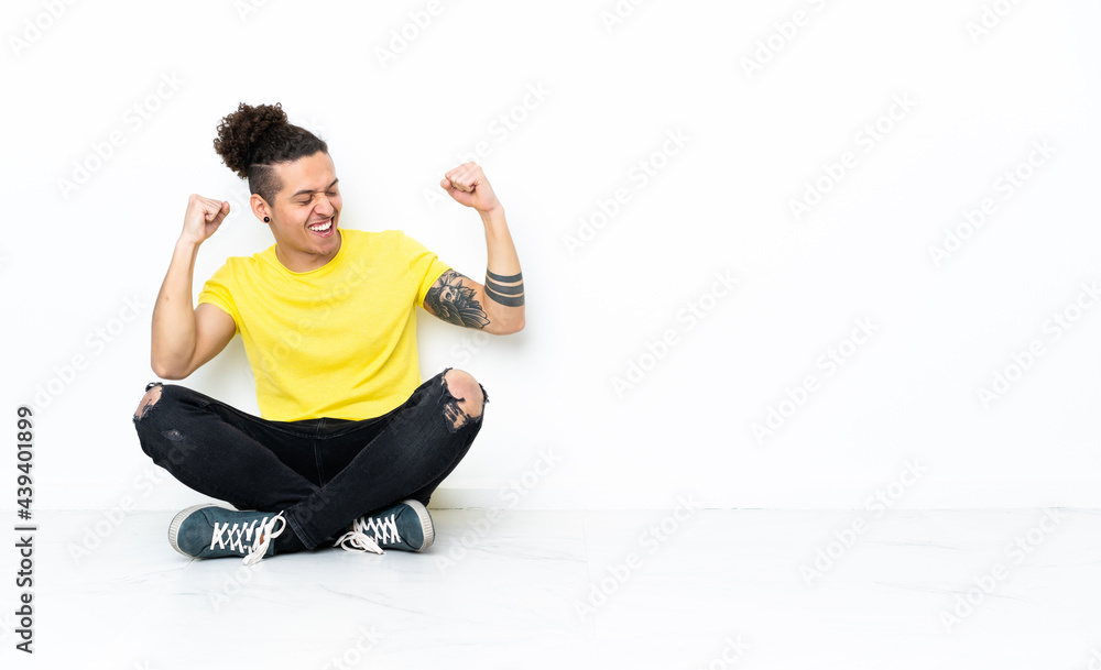 Caucasian man sitting on the floor celebrating a victory Caucasian man sitting on the floor celebrating a victory