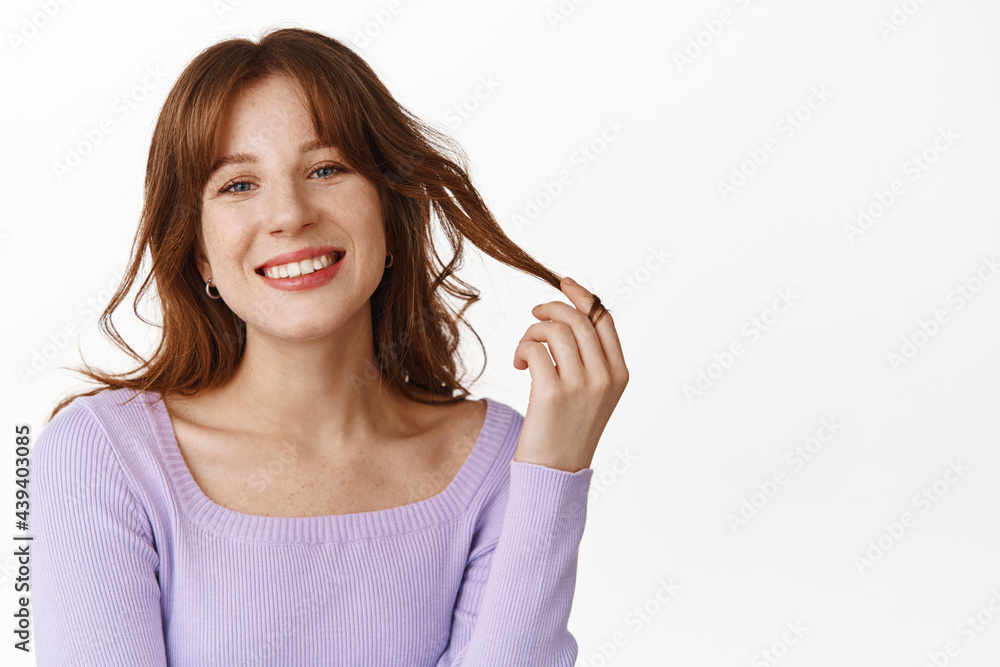 Lifestyle and fashion concept. Beautiful and stylish woman touch her hair, new hairstyle with bangs, looking happy and smiling, wearing purple blouse, white background Lifestyle and fashion concept. Beautiful and stylish woman touch her hair, new hairstyle with bangs, looking happy and smiling, wearing purple blouse, white background
