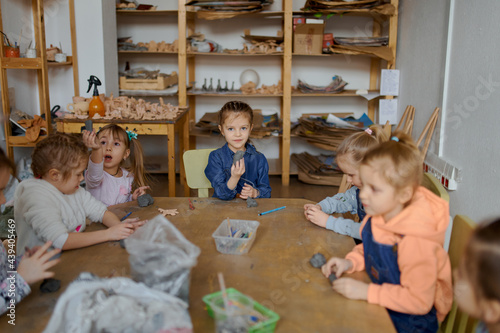 group of 5 year old preschool children in an art school learn to sculpt from clay photo