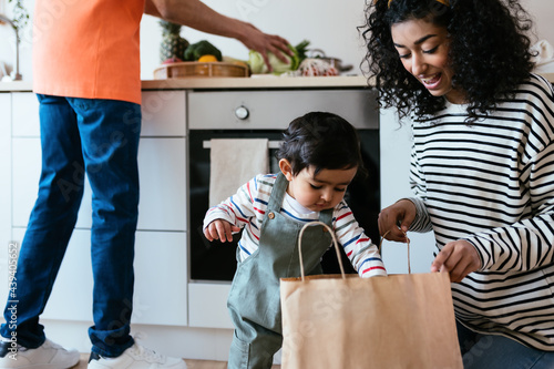 Indian baby helping mother to unpack groceries
