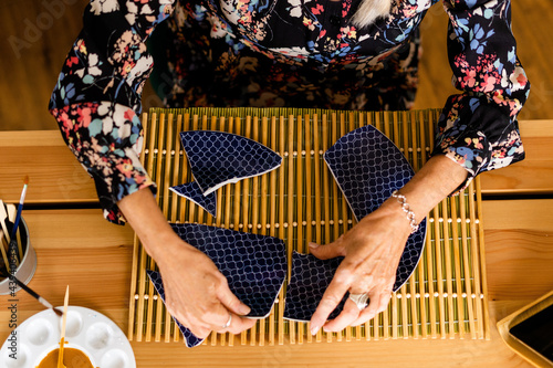 Top view of woman repairing a broken plate with gold photo