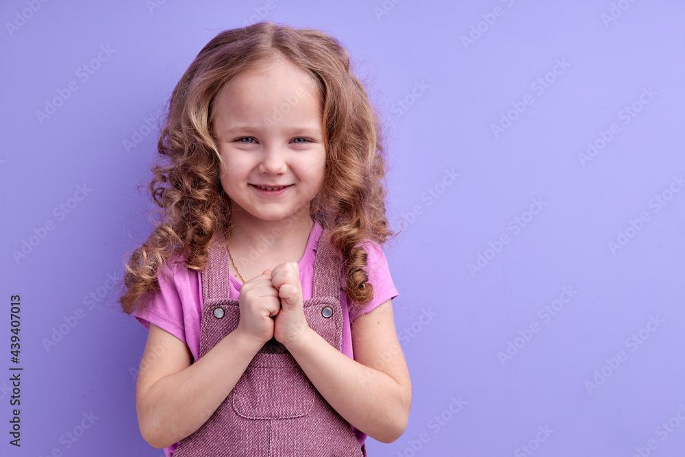 Portrait of sneaky scheming little girl in casual wear thinking over cunning prank and smirking, disobedient child having sly tricky plans in mind. indoor studio shot isolated on purple background Portrait of sneaky scheming little girl in casual wear thinking over cunning prank and smirking, disobedient child having sly tricky plans in mind. indoor studio shot isolated on purple background