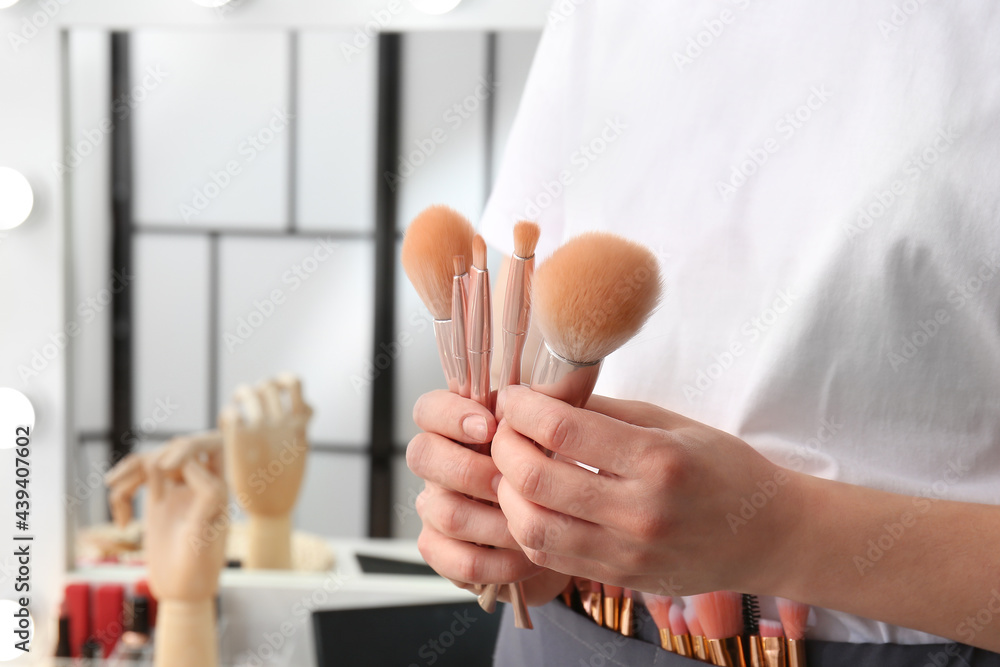 Woman with set of makeup brushes in beauty salon, closeup Woman with set of makeup brushes in beauty salon, closeup