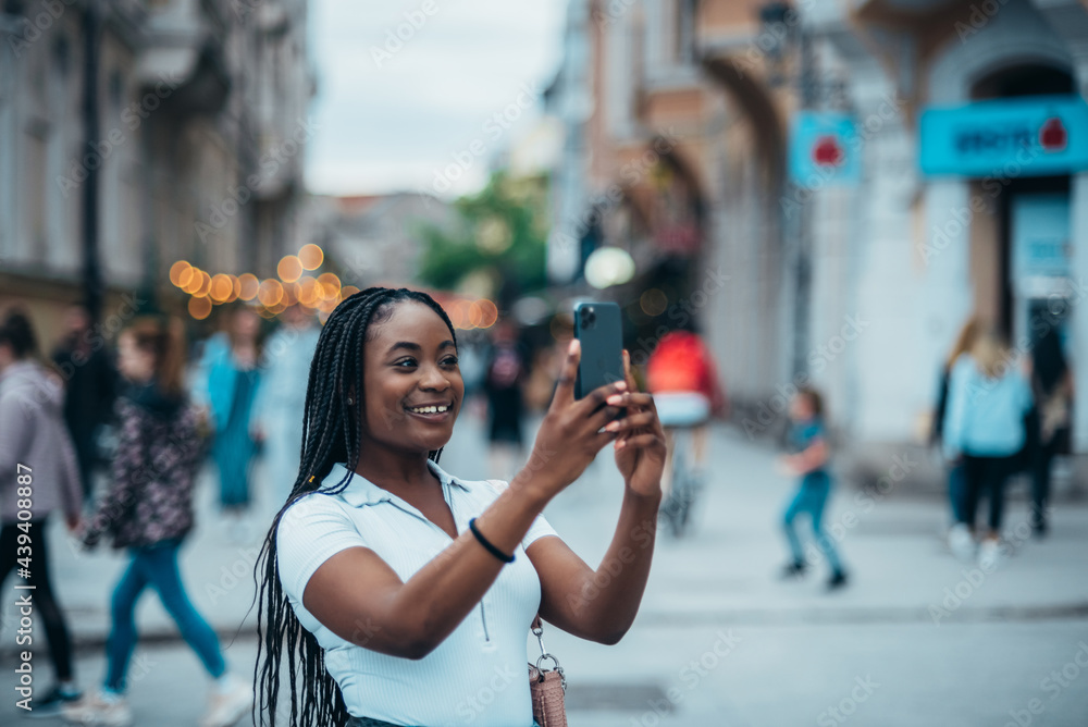 Beautiful african american woman taking selfie with a samrtphone outside