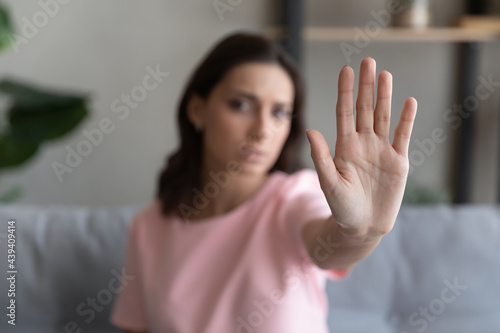 Close up focus on Arabian woman hand showing stop gesture, blurred background, strong young female protesting against domestic violence and abuse, bullying, saying no to gender discrimination