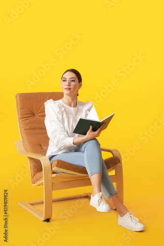 Young woman with book sitti...