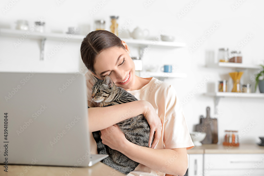 Beautiful young woman with cute cat in kitchen Beautiful young woman with cute cat in kitchen