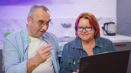 Wallpaper Mural Happy old middle aged couple using laptop talking together doing online shopping, senior mature retired family reading discussing internet computer news. Torontodigital.ca