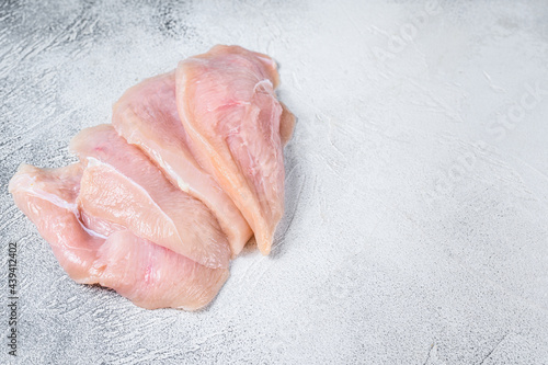 Raw sliced chicken breast fillet steaks. White background. Top view. Copy space