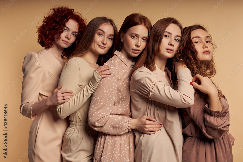 Cute redhead young women leaning on shoulder of each other isolated on beige background, banner. Copy space. Caucasian females standing closely, feeling safety, reliability and tenderness Cute redhead young women leaning on shoulder of each other isolated on beige background, banner. Copy space. Caucasian females standing closely, feeling safety, reliability and tenderness