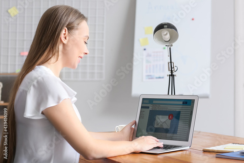 Young woman with laptop che...