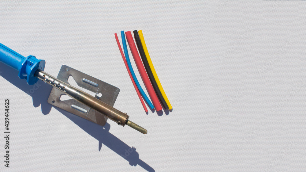 Naklejka premium Electric soldering iron with blue handle on white background