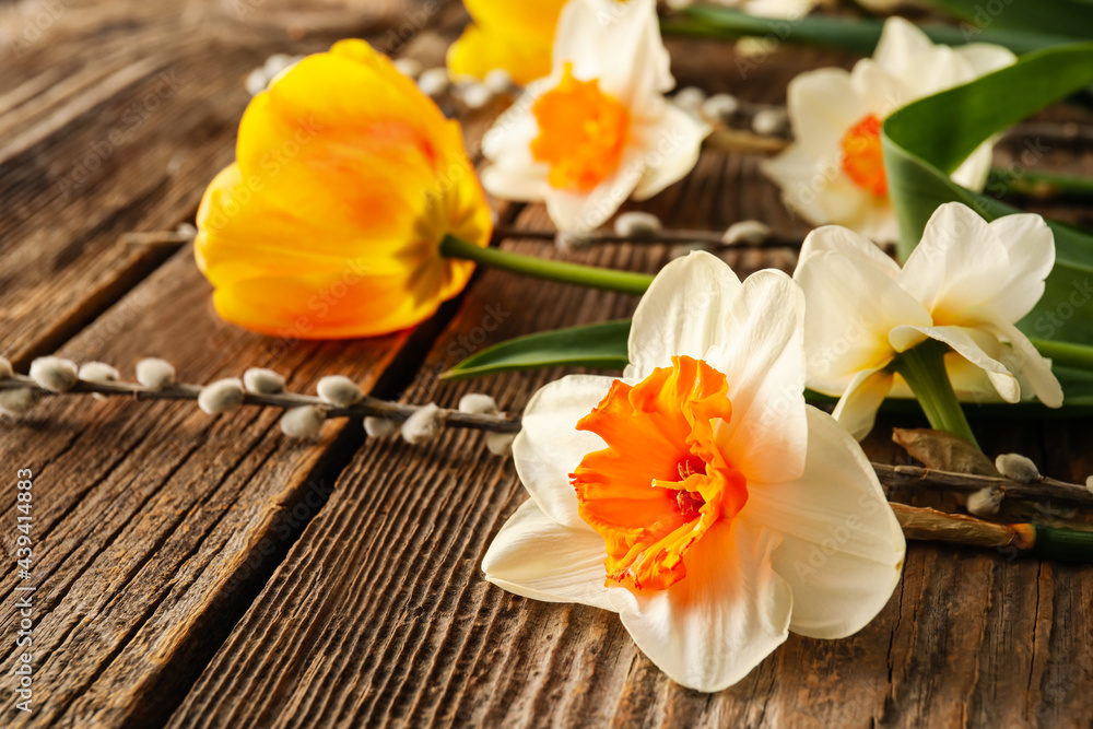 Beautiful flowers and willow on wooden background, closeup Beautiful flowers and willow on wooden background, closeup