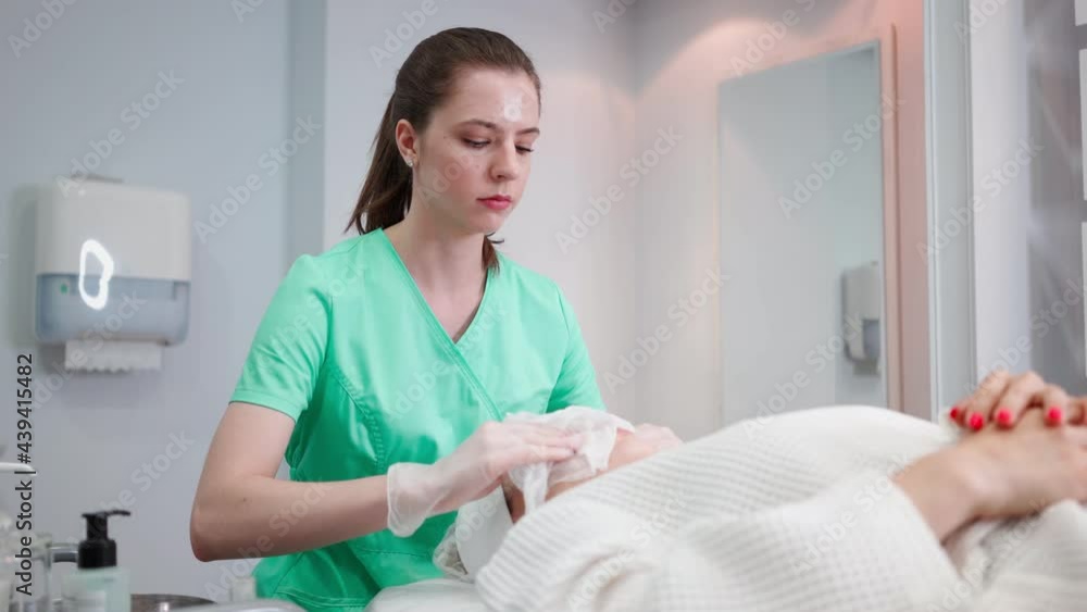 Professional Female Beautician Makes a Face Rejuvenation and Cleansing Procedure for Beautiful Girl in Beauty Salon. Facial Skin and Anti-aging Treatment. Cosmetology and Facial Skin Care. Spa Concept