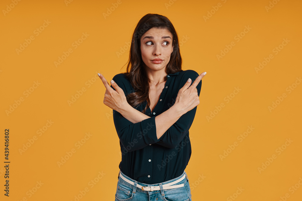 Attractive young woman in casual clothing pointing copy space Attractive young woman in casual clothing pointing copy space