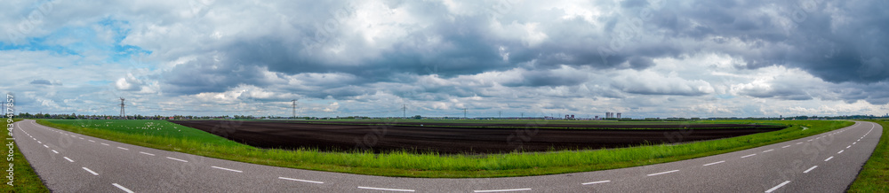 panorama of agricultural fields on the other side of a small dike with a fisheye effect