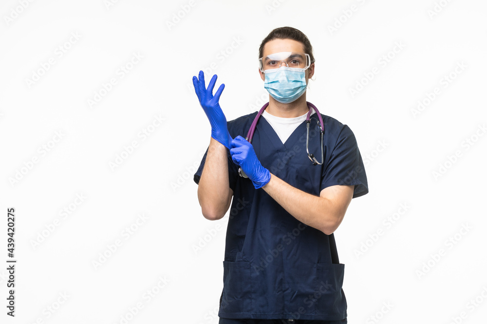 Doctor puts on gloves and wearing medical mask isolated on white background. Medical concept corona virus Doctor puts on gloves and wearing medical mask isolated on white background. Medical concept corona virus