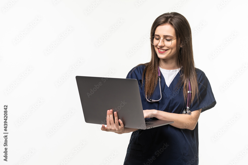 Young female doctor with laptop on grey background Young female doctor with laptop on grey background