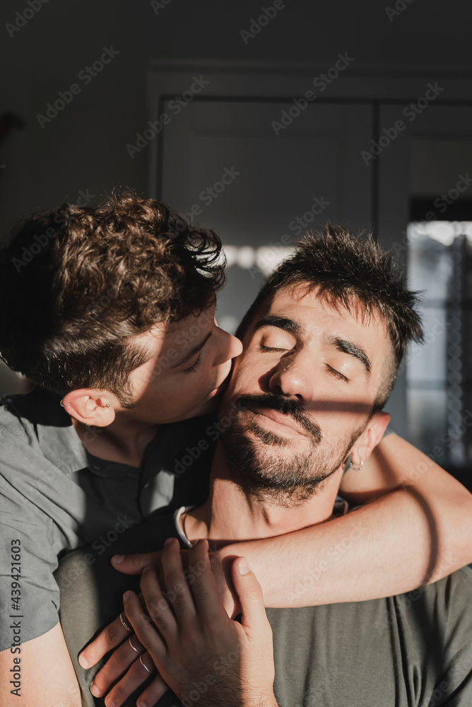 Same sex couple kissing and hugging in the room. Same sex couple kissing and hugging in the room.