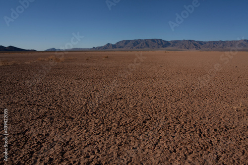 A barren desert landscape with distant mountains